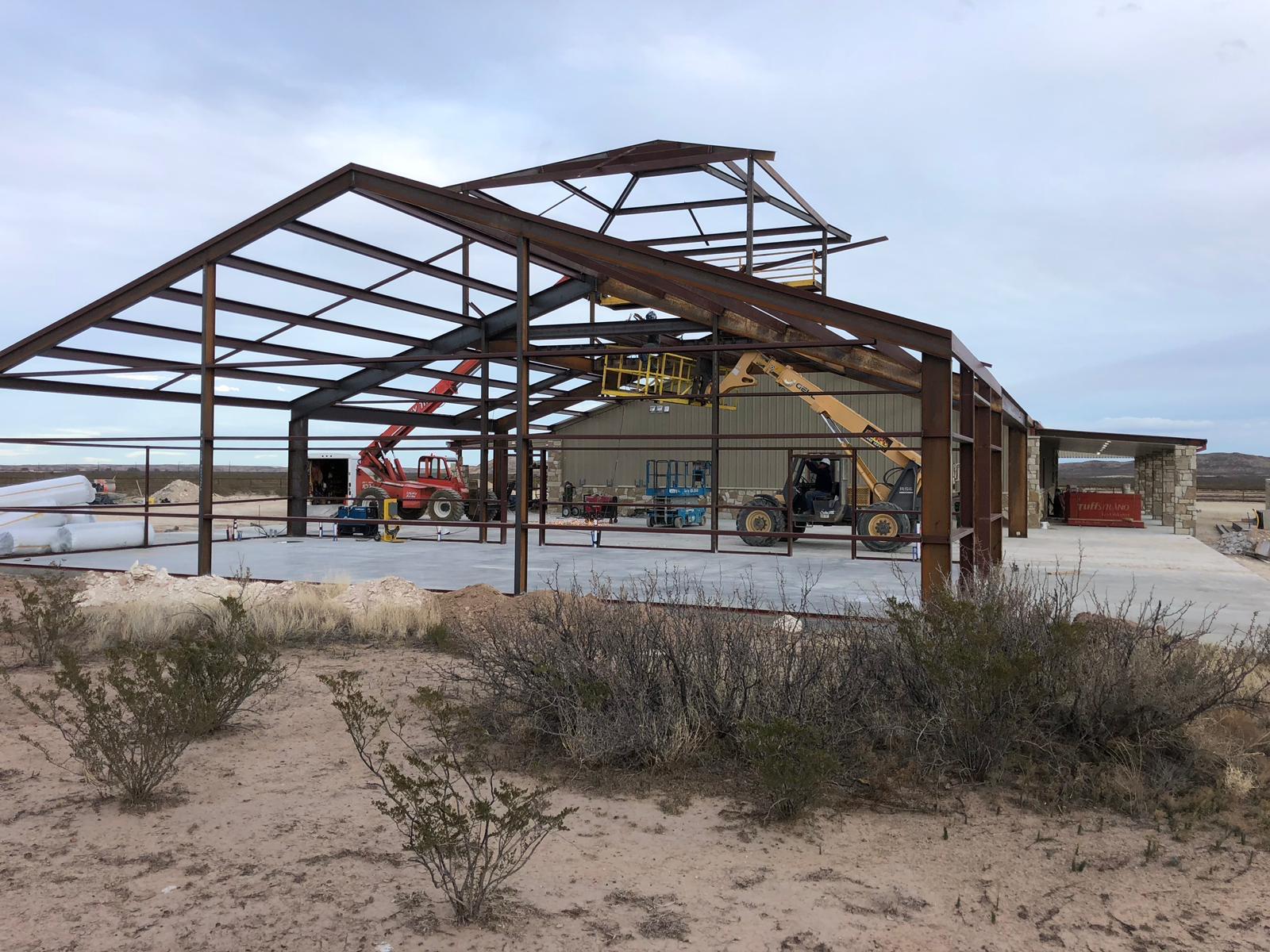 Bare steel frame of a metal building during erection on a West Texas job site