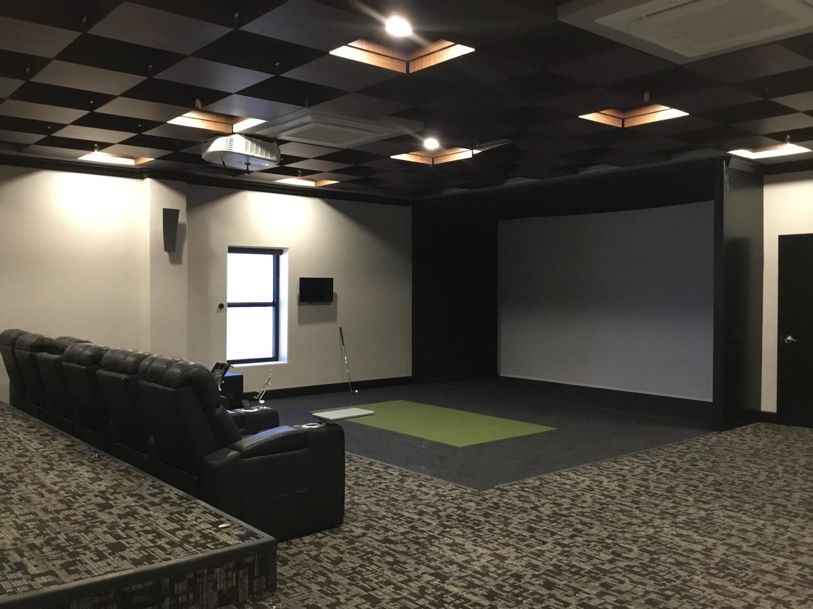 Finished interior room with coffered ceiling, projector and seating inside a metal building